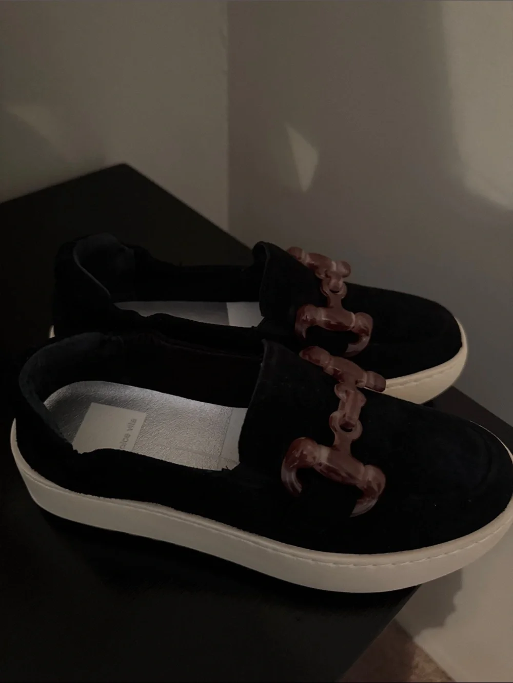 Dolce Vita Black Suede women’s Slip-On Loafers with Brown Accent Chain.